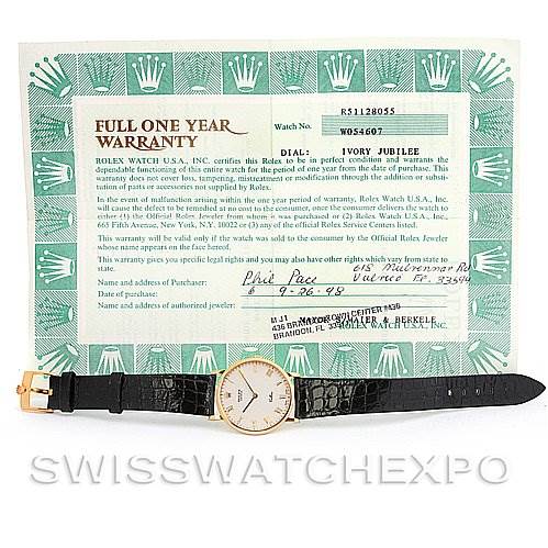 This image shows a Rolex Cellini 5112 Yellow Gold Beige Dial 5112 Yellow Gold Beige Dial watch positioned flat with its warranty card in the background.