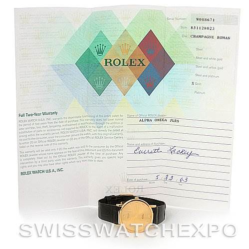 The image shows a Rolex Cellini 5112 Men's Yellow Gold Champagne Dial 5112 Men's Yellow Gold Champagne Dial watch with a black leather strap, placed in front of its warranty and certification papers.