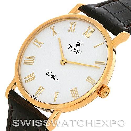The image displays a close-up of the face and part of the strap of a Rolex Cellini 5112 Yellow Gold  5112 Yellow Gold  watch, showcasing its gold casing and Roman numeral indices.