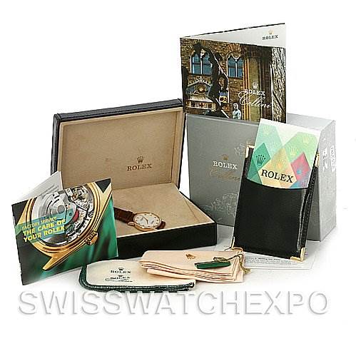 The image shows a Rolex Cellini 5115 Men's Yellow Gold Mother of Pearl Dial 5115 Men's Yellow Gold Mother of Pearl Dial model watch placed in an open box, surrounded by booklets, a cleaning cloth, and a cardholder.