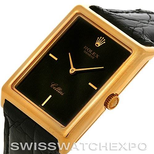 The Rolex Cellini 4105 Men's Yellow Gold Black Dial 4105 Men's Yellow Gold Black Dial watch is shown at an angle highlighting the front rectangular dial and its adjacent gold crown, with a black leather strap.