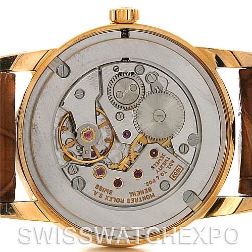The image shows the back view of a Rolex Cellini 5116 Men's Yellow Gold Black Dial 5116 Men's Yellow Gold Black Dial watch, highlighting the intricate mechanical movement and parts inside.