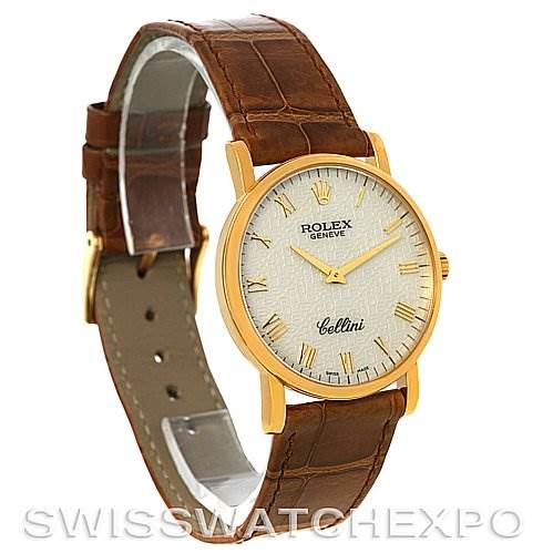 This image shows a Rolex Cellini 5115 Men's Yellow Gold Beige Dial 5115 Men's Yellow Gold Beige Dial watch at an oblique angle, featuring its gold case, white textured dial, and brown leather strap.