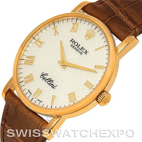 The Rolex Cellini 5115 Men's Yellow Gold Beige Dial 5115 Men's Yellow Gold Beige Dial watch is displayed at a slight angle, showing its gold case, white dial with Roman numerals, and brown leather strap.