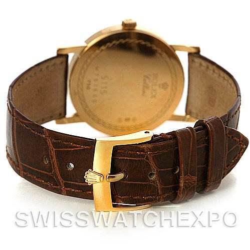 This image shows the rear view of a Rolex Cellini 5115 Men's Yellow Gold Silver Dial 5115 Men's Yellow Gold Silver Dial watch featuring a gold back case and a brown leather strap with a gold buckle.