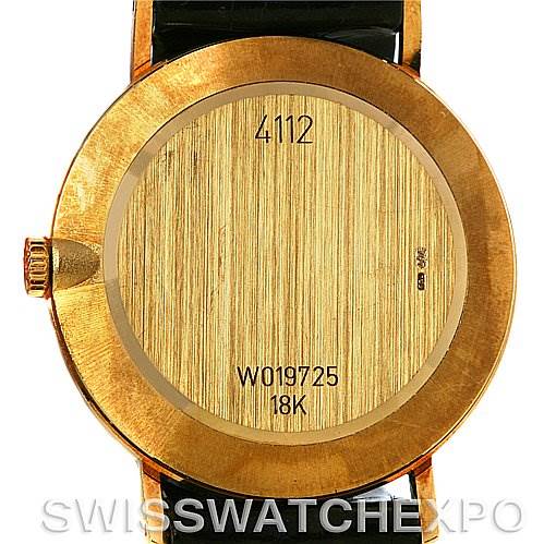 The image shows the back case of a Rolex Cellini 4112 Yellow Gold White Dial 4112 Yellow Gold White Dial watch, revealing its inscriptions and an 18K gold setting.