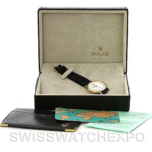 The image shows a Rolex Cellini 4112 Yellow Gold White Dial 4112 Yellow Gold White Dial watch inside its box, displayed at an angle, with accompanying documents and holder.