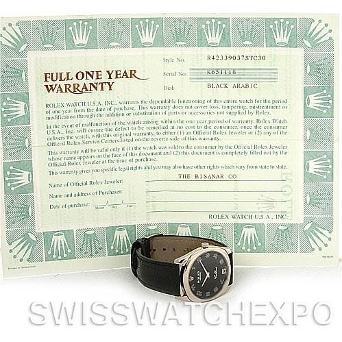 The image shows a Rolex Cellini 4233 Men's White Gold Black Dial 4233 Men's White Gold Black Dial watch with a black strap, placed in front of its full one-year warranty document.