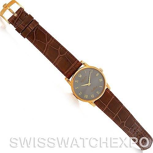 This image shows a Rolex Cellini 5116 Men's Yellow Gold Grey Dial 5116 Men's Yellow Gold Grey Dial watch from a top-down angle, featuring a brown leather strap and a gold case with a black dial.