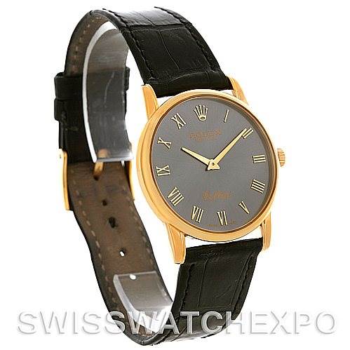 The image shows a Rolex Cellini 5116 Men
s Yellow Gold Grey Dial 5116 Men
s Yellow Gold Grey Dial watch at an angle, highlighting its black leather strap, gold case, and black dial with Roman numerals.