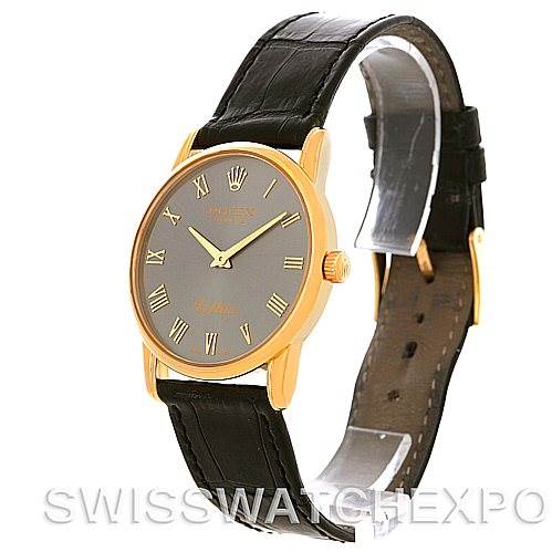 The Rolex Cellini 5116 Men
s Yellow Gold Grey Dial 5116 Men
s Yellow Gold Grey Dial watch is shown at an angled view, highlighting its round gold case, black leather strap, and Roman numeral dial.