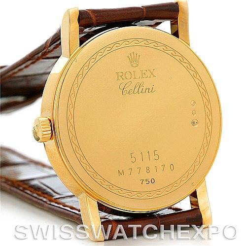 The image shows the back case of a Rolex Cellini 5115 Men's Yellow Gold Silver Dial 5115 Men's Yellow Gold Silver Dial watch, highlighting its engravings and crown, with a visible leather strap.