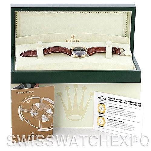 This image shows a Rolex Cellini 4233 Men's White Gold Black Dial 4233 Men's White Gold Black Dial watch, with its face and strap, displayed in an open box with accompanying manuals and service documents.