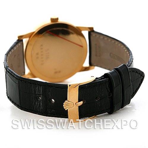 The image shows the back view of a Rolex Cellini 5116 Men's Yellow Gold Black Dial 5116 Men's Yellow Gold Black Dial watch, featuring its gold case and black leather strap with a gold clasp.