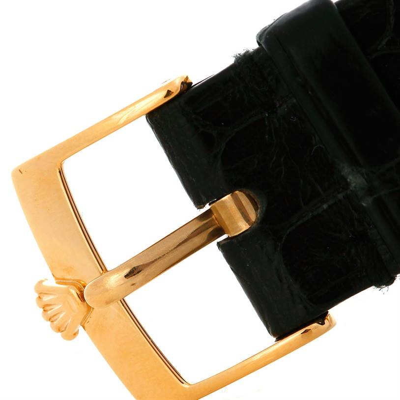 This close-up shows the buckle of a Rolex Cellini 5115 Men's Yellow Gold Silver Dial 5115 Men's Yellow Gold Silver Dial watch strap, highlighting the gold clasp and black leather.