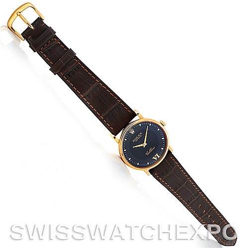 The Rolex Cellini 5115 Men's Yellow Gold Black Dial 5115 Men's Yellow Gold Black Dial watch is shown from a top-down angle, displaying the full watch face, brown leather strap, and gold buckle.