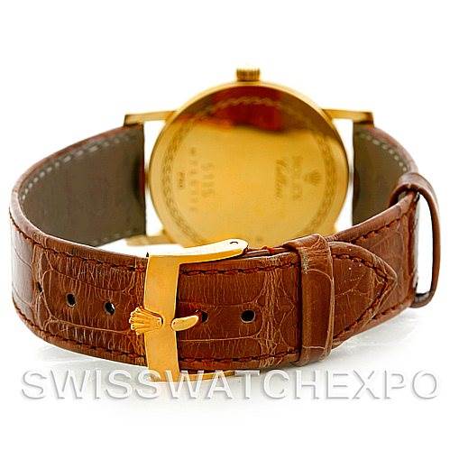 This Rolex Cellini 5115 Men's Yellow Gold Beige Dial 5115 Men's Yellow Gold Beige Dial watch is shown from the rear, featuring its gold caseback and brown leather strap with a gold buckle.