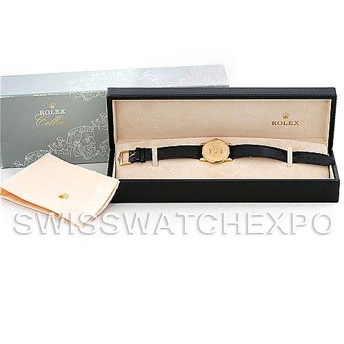 The image shows a Rolex Cellini 5116 Men's Yellow Gold Champagne Dial 5116 Men's Yellow Gold Champagne Dial watch in its box, with a gold case and black strap, alongside a cleaning cloth.