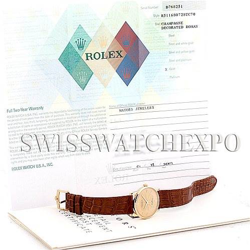 This image shows a Rolex Cellini 5116 Men
s Yellow Gold Champagne Dial 5116 Men
s Yellow Gold Champagne Dial watch placed in front of its warranty paper and packaging.