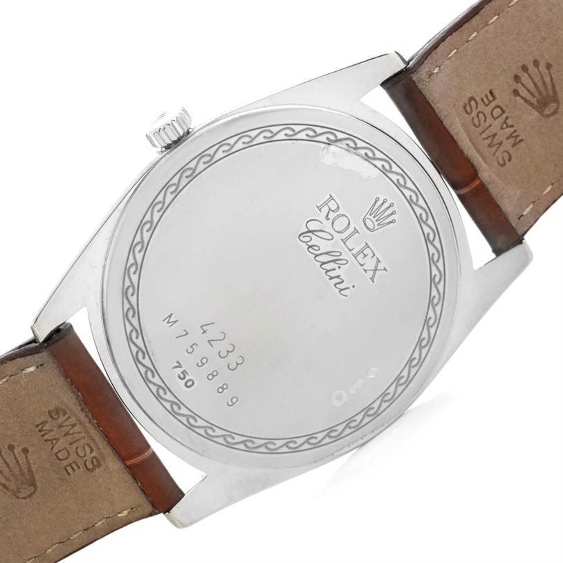 This image shows the back case and partially visible leather bands of a Rolex Cellini 4233 Men's White Gold White Dial 4233 Men's White Gold White Dial watch, emphasizing its engraved details.