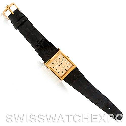 This image shows a Rolex Cellini 4027 Men's Yellow Gold Champagne Dial 4027 Men's Yellow Gold Champagne Dial watch laid flat, displaying its rectangular face and black strap from a top-down angle.