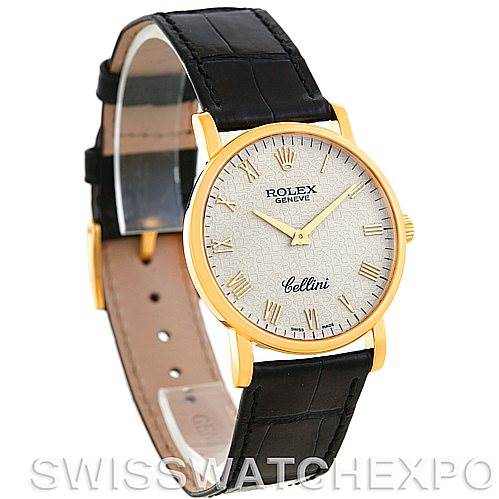 The Rolex Cellini 5115 Men's Yellow Gold Beige Dial 5115 Men's Yellow Gold Beige Dial watch is shown at a slight angle, highlighting its gold case, textured dial, and black leather strap.