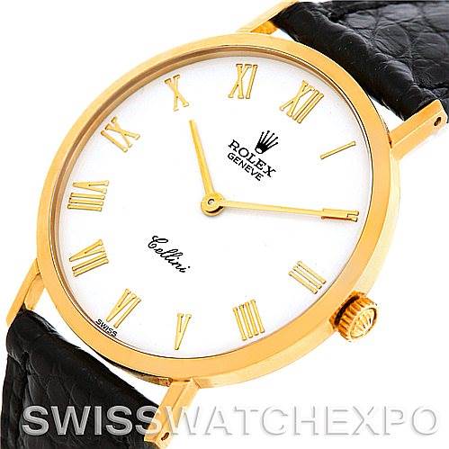 The image shows a close-up of the cell phone watch face at an oblique angle, highlighting the gold casing, crown, Roman numerals, and black leather strap.