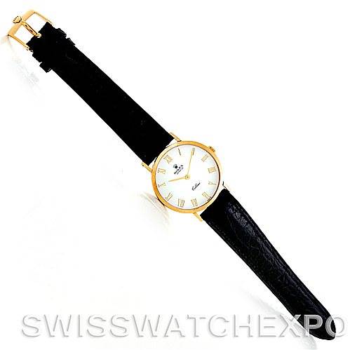 The Cellini model by Rolex is shown from a top-down angle, displaying its black leather strap and round white dial with Roman numerals.