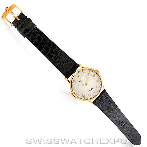 This image shows a top-down view of a Rolex Cellini 5112 Men's Yellow Gold Beige Dial 5112 Men's Yellow Gold Beige Dial watch with a gold case and black leather strap.