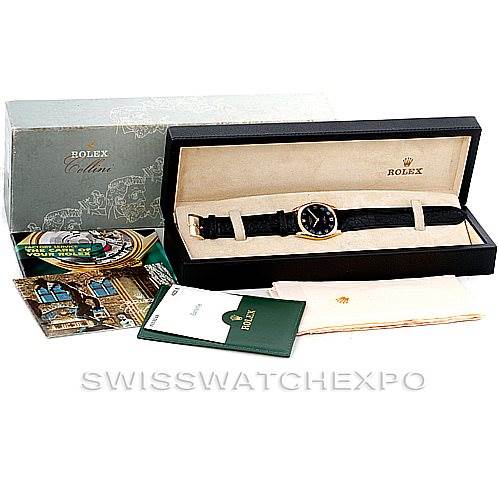 The image shows a Rolex Cellini 4233 Men's Yellow Gold Black Dial 4233 Men's Yellow Gold Black Dial watch, its box, booklets, and warranty card displayed at an angle.