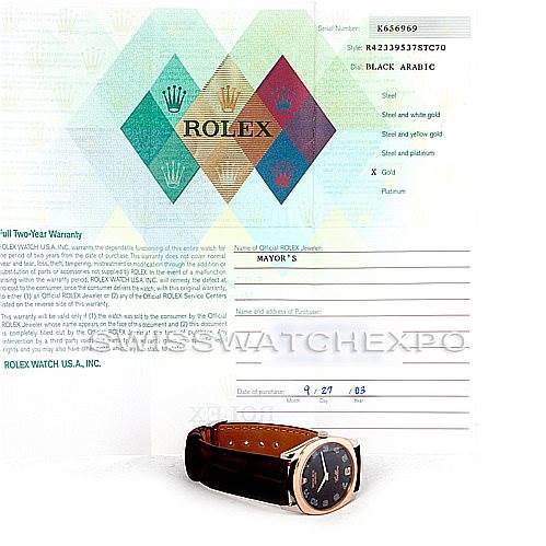 The image shows a side angle of a Rolex Cellini 4233 Men's White Gold Black Dial 4233 Men's White Gold Black Dial watch placed in front of its warranty card.