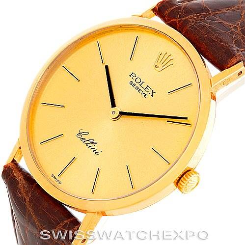 The Rolex Cellini 4112 Men's Yellow Gold Champagne Dial 4112 Men's Yellow Gold Champagne Dial watch is seen from a slightly angled view, showing its gold dial, case, crown, and brown leather strap.