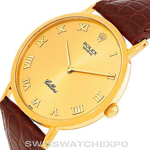 The Rolex Cellini 4112 Men's Yellow Gold Champagne Dial 4112 Men's Yellow Gold Champagne Dial watch is shown from a slightly tilted angle, displaying its gold face, Roman numerals, and brown leather strap.