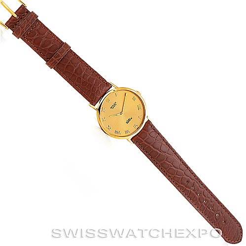 The image shows a top-down view of a Rolex Cellini 4112 Men's Yellow Gold Champagne Dial 4112 Men's Yellow Gold Champagne Dial watch with a gold face and a brown leather strap.