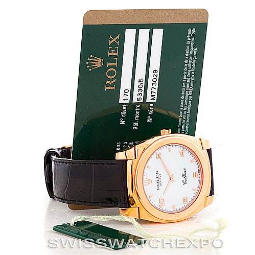 The image shows a Rolex Cellini 5330 Men's Rose Gold White Dial 5330 Men's Rose Gold White Dial watch at an angle displaying the watch face and a green Rolex warranty card behind it.