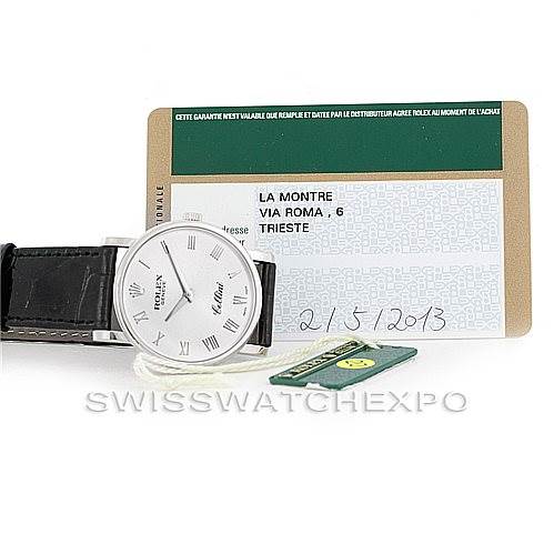 The image shows the front view of a Rolex Cellini 5115 Men's White Gold Silver Dial 5115 Men's White Gold Silver Dial watch, alongside its warranty card and a small green tag.