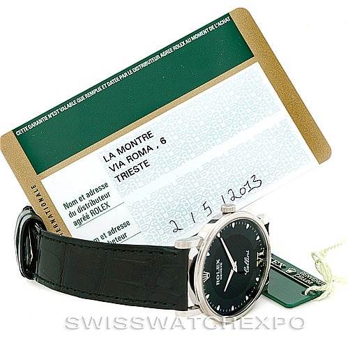 The image shows the Rolex Cellini 5115 Men's White Gold Black Dial 5115 Men's White Gold Black Dial watch at an angle displaying the face and strap, along with its warranty card and tags.