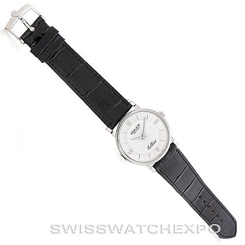 The image shows a top view of a Rolex Cellini 5115 Men's White Gold Silver Dial 5115 Men's White Gold Silver Dial watch with a black leather strap and a silver dial.