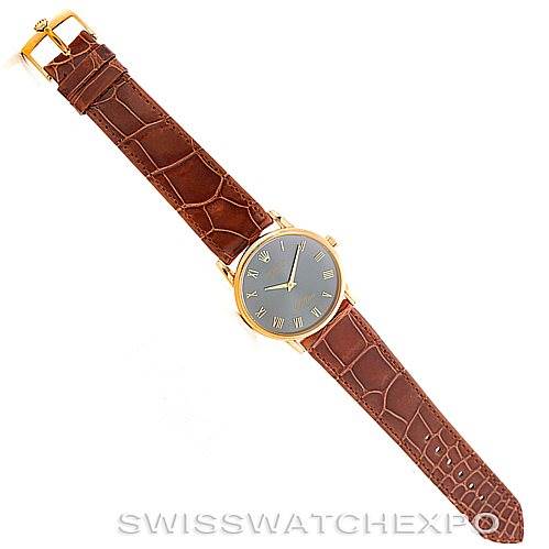 This image shows a top-down view of a Rolex Cellini 5116 Men's Yellow Gold Grey Dial 5116 Men's Yellow Gold Grey Dial watch, displaying its brown leather strap and gold case with a black dial.