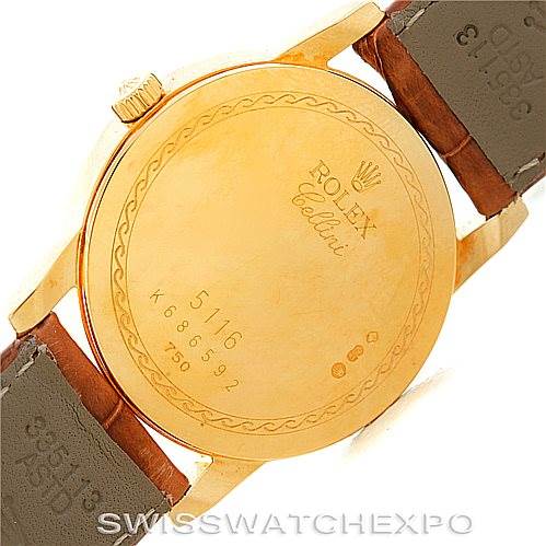 The image shows the back case of a Rolex Cellini 5116 Men's Yellow Gold Grey Dial 5116 Men's Yellow Gold Grey Dial watch, highlighted with engravings and the attached leather straps.