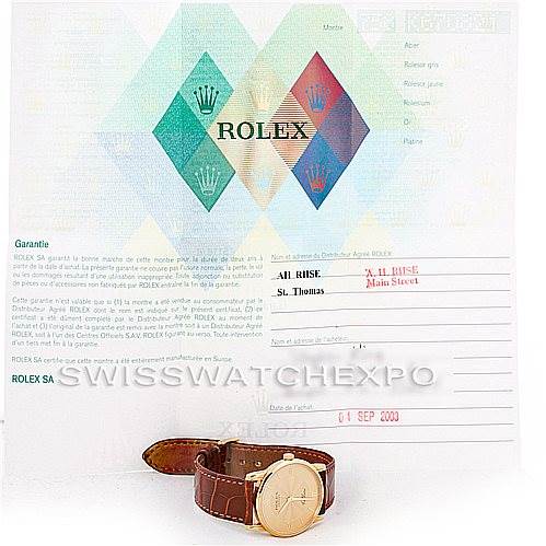 The image shows a Rolex Cellini 5116 Men's Yellow Gold Champagne Dial 5116 Men's Yellow Gold Champagne Dial watch with a brown leather strap, placed in front of its guarantee certificate.