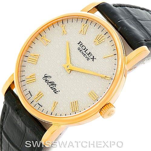 The image shows a close-up, angled view of a Rolex Cellini 5115 Men
s Yellow Gold Beige Dial 5115 Men
s Yellow Gold Beige Dial watch, highlighting the gold case, dial, Roman numerals, and black leather strap.