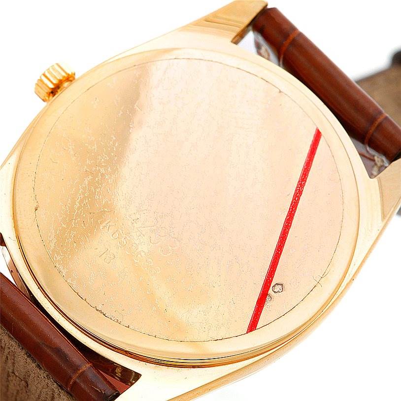 The image shows the back case and part of the leather strap of a Rolex Cellini 4233 Men's Yellow Gold White Dial 4233 Men's Yellow Gold White Dial watch at an oblique angle.