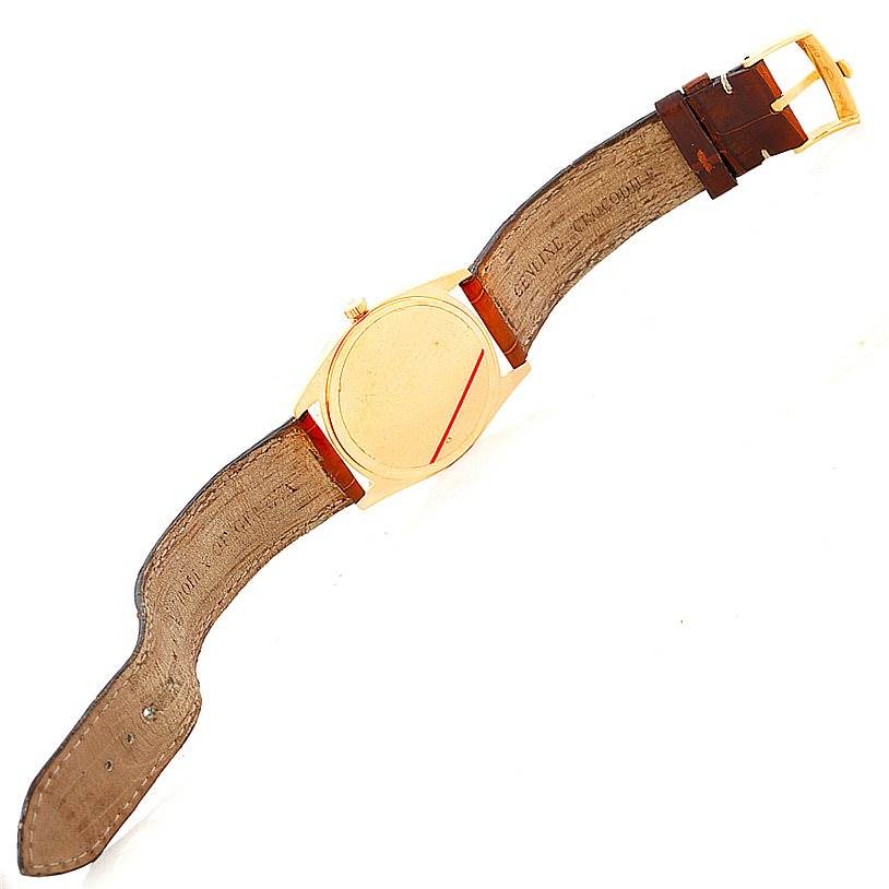 This image shows a top view of the Rolex Cellini 4233 Men's Yellow Gold White Dial 4233 Men's Yellow Gold White Dial watch, highlighting its gold case, leather strap, and buckle.