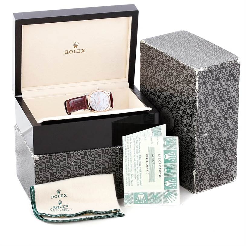 The Rolex Cellini 4233 Men's White Gold White Dial 4233 Men's White Gold White Dial watch is shown from an oblique angle, along with its box, warranty card, and polishing cloth.
