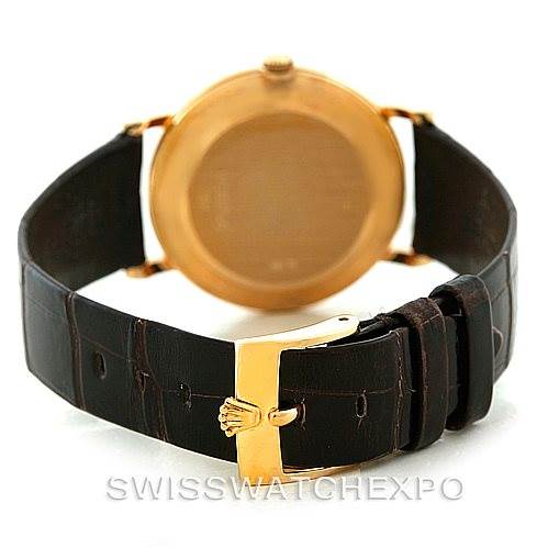 The image shows the back view of a Rolex Cellini 5112 Men's Yellow Gold Mother of Pearl Dial 5112 Men's Yellow Gold Mother of Pearl Dial watch and its leather strap, focusing on the gold clasp with the Rolex logo.