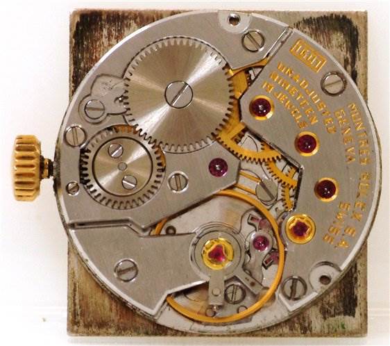 The image shows a close-up of the movement and inner gears of a Rolex Cellini 4016 Men's Yellow Gold White Dial 4016 Men's Yellow Gold White Dial model watch.