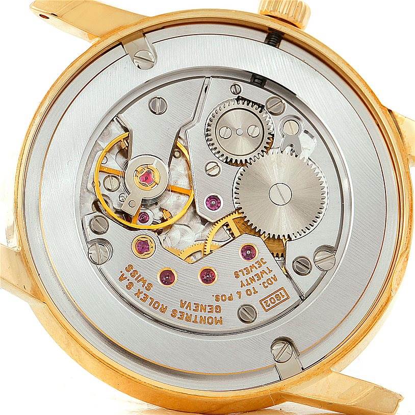 The image shows the internal mechanical movement of a Rolex Cellini 5116 Men's Yellow Gold Grey Dial 5116 Men's Yellow Gold Grey Dial watch from a rear angle, showcasing its intricate gears and components.
