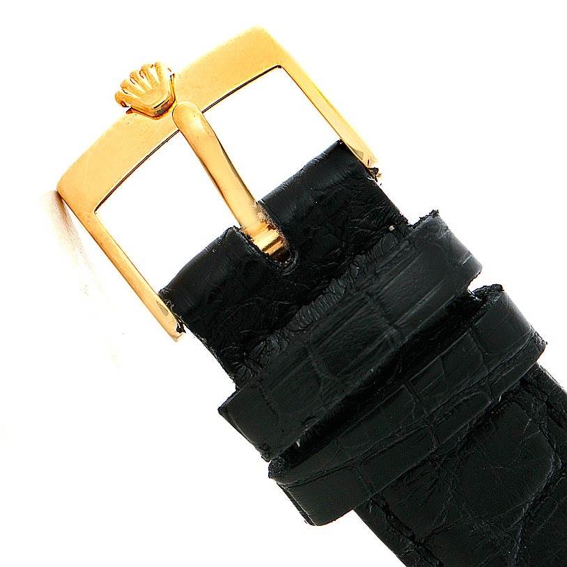 This image shows a close-up of a Rolex Cellini 5116 Men's Yellow Gold Grey Dial 5116 Men's Yellow Gold Grey Dial model's gold buckle and black leather strap.