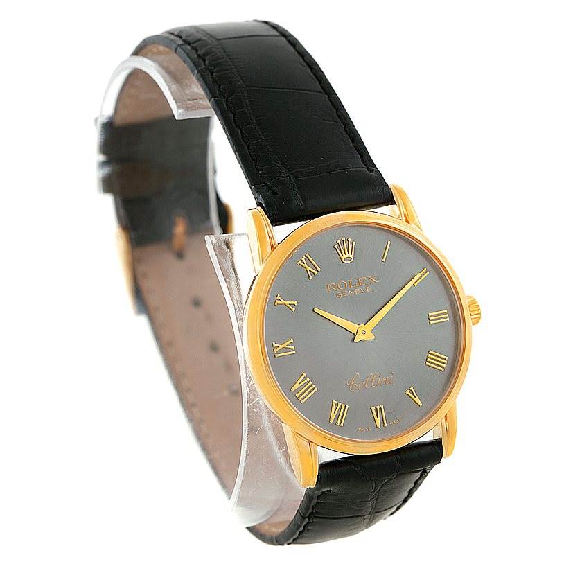 The Rolex Cellini 5116 Men's Yellow Gold Grey Dial 5116 Men's Yellow Gold Grey Dial watch is shown at a three-quarter angle, displaying its face, Roman numerals, and black leather strap.
